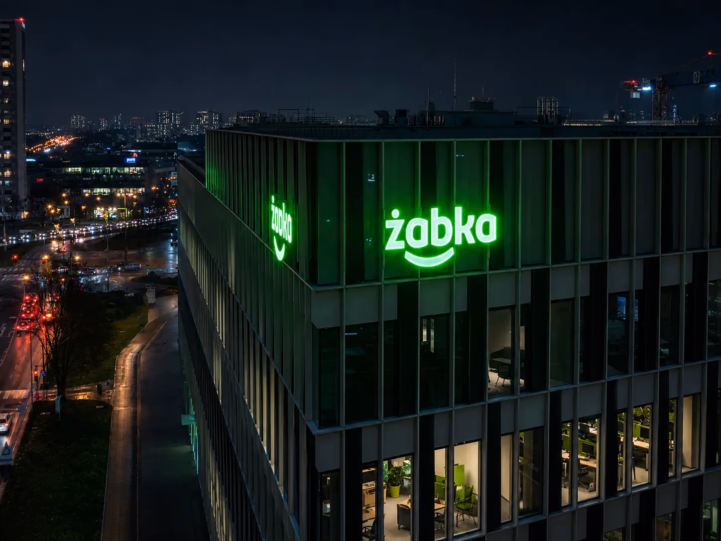 Siedziba Grupy Żabka nocą z podświetlonym logo